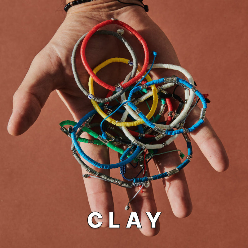 Clay brads bracelets on open hand with neutral background.
