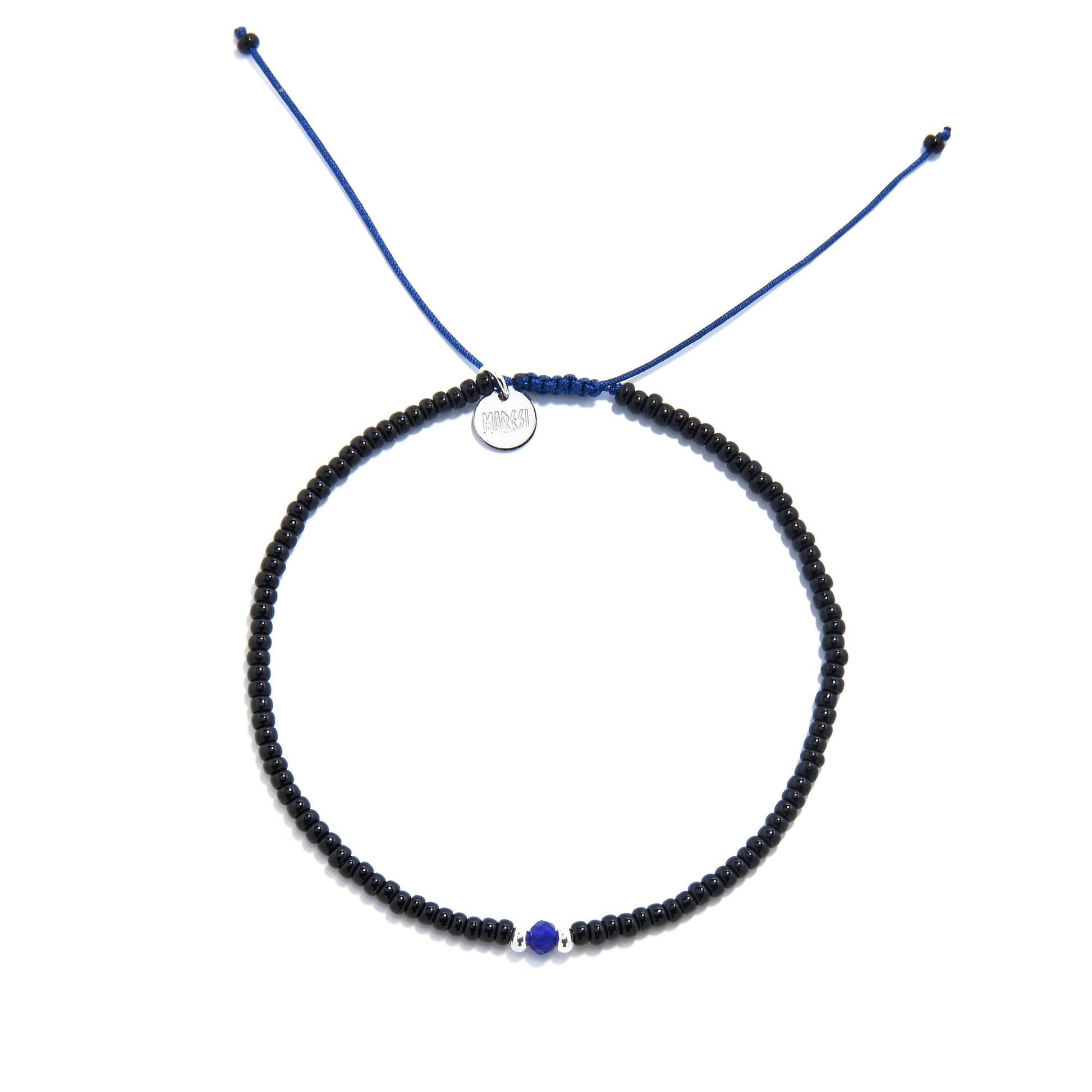 Flat lay of adjustable bead bracelet with black seed beads and blue accent on blue cord