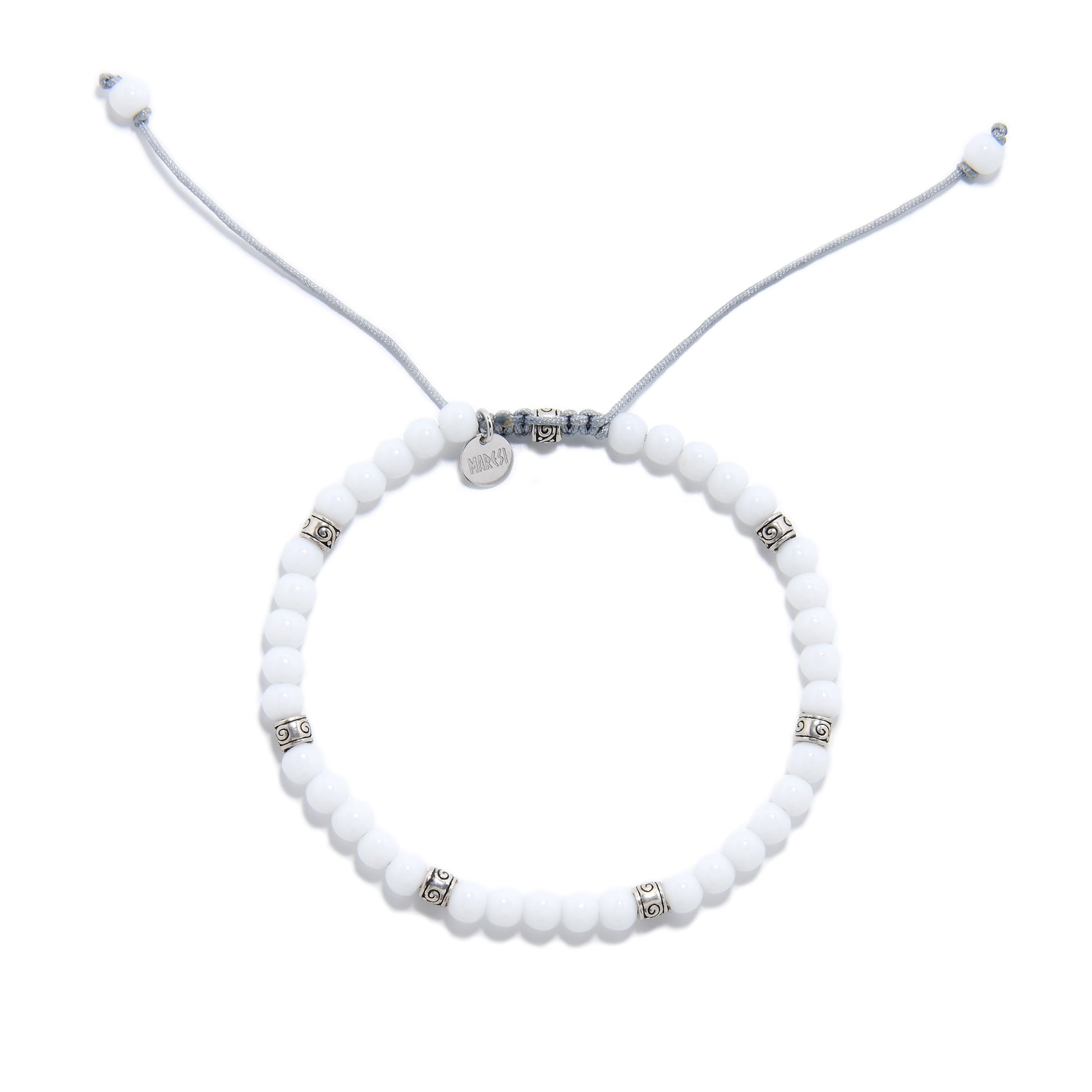 Overhead view of round white jade bracelet with adjustable drawstring and decorative metal beads.
