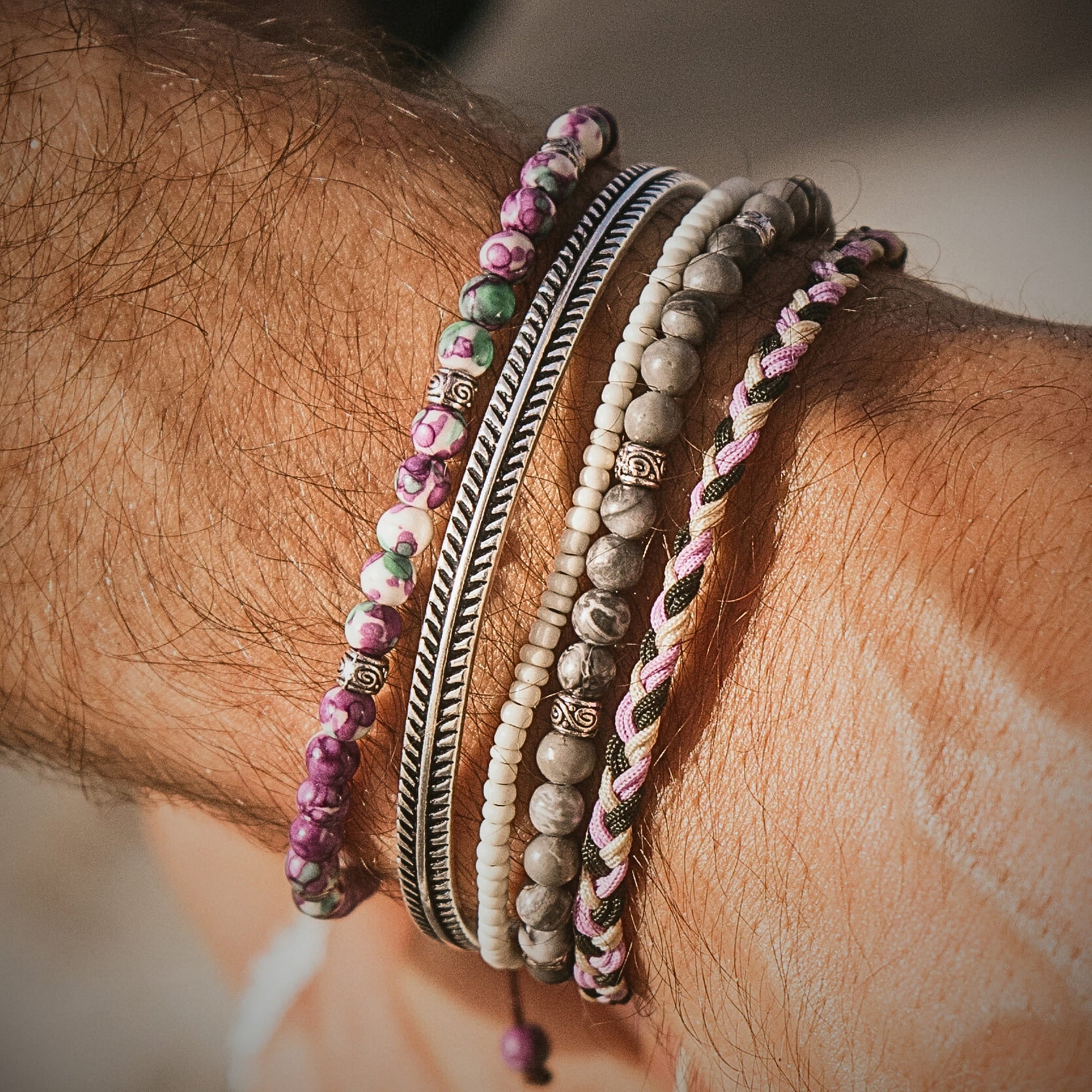 Wrist with five stacked Amalfi bracelets in mixed textures and colors