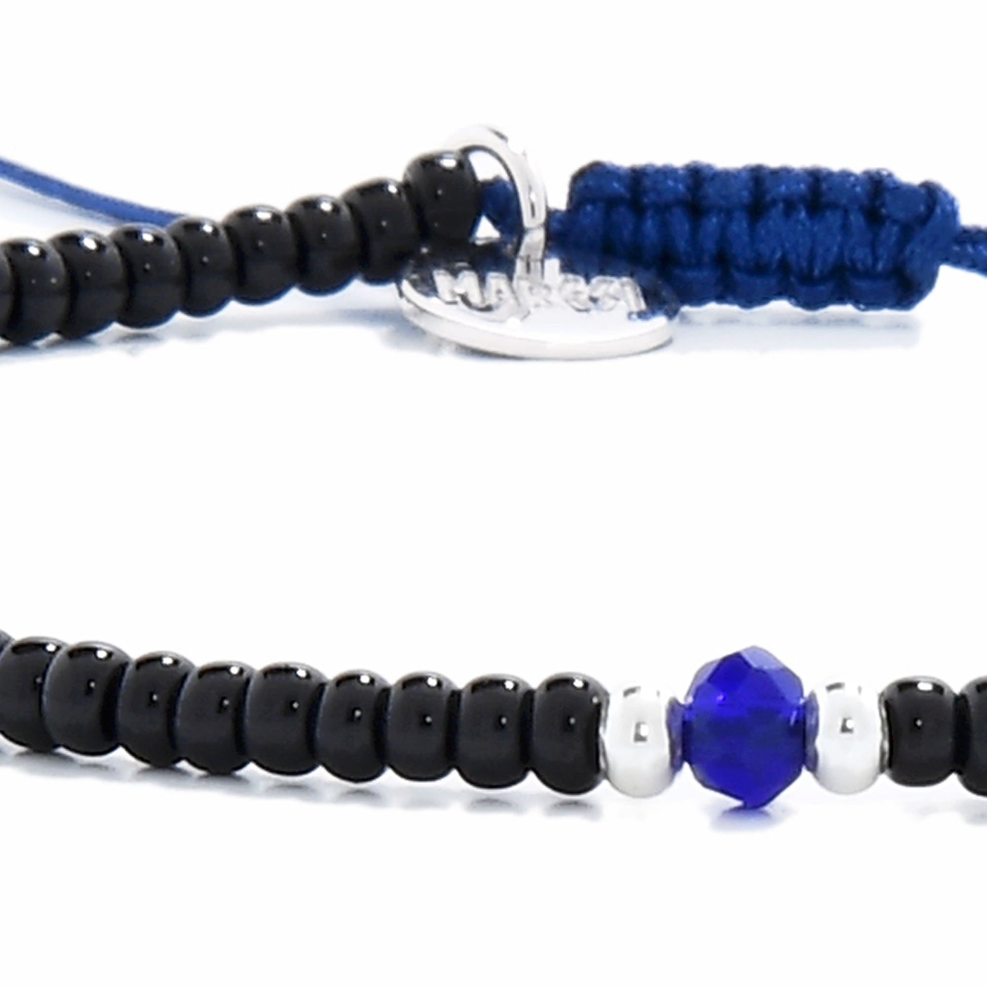 Close-up of black bead bracelet with white spacers and faceted blue center bead