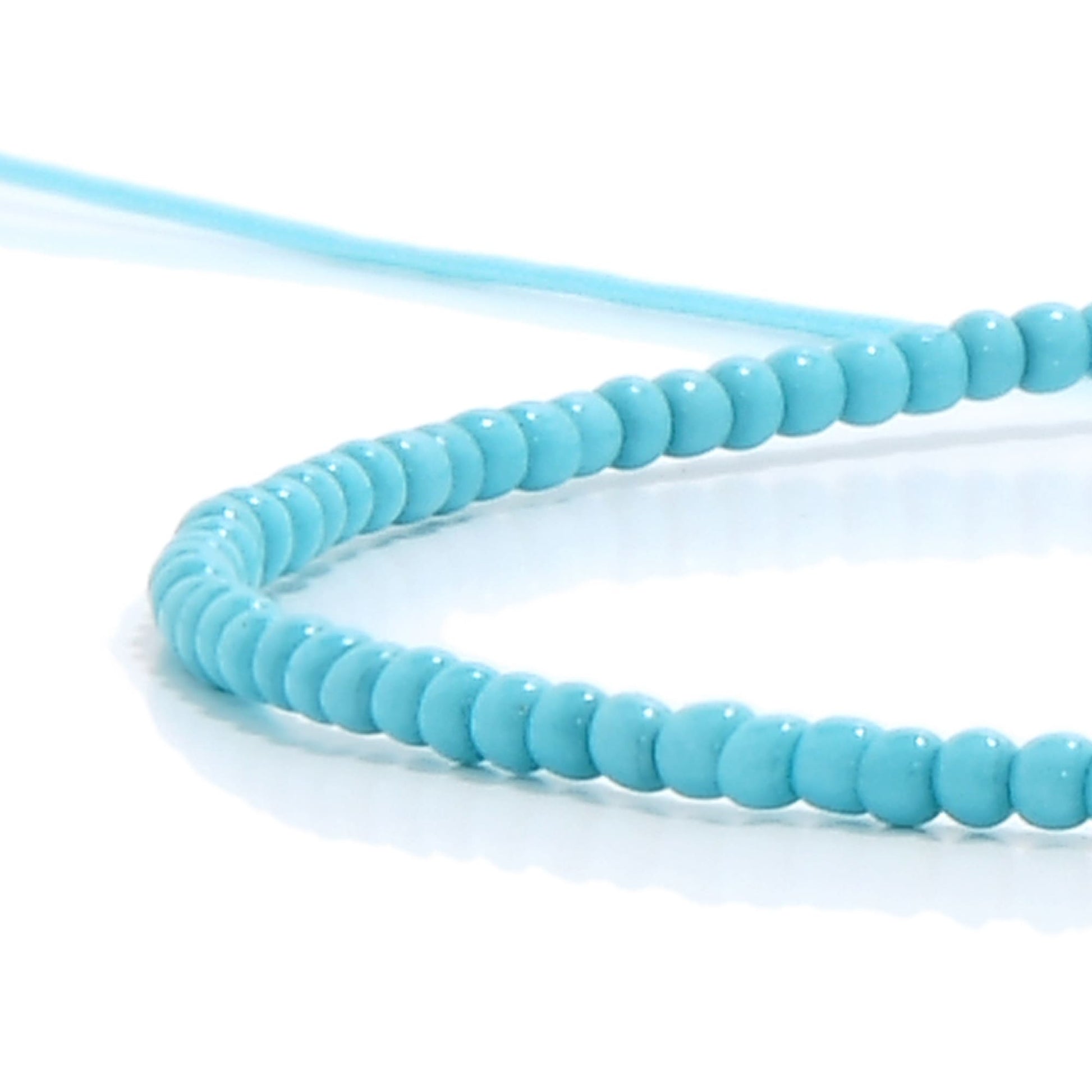 A macro photo showing the smooth, round turquoise-colored beads used to create our stylish mens beaded bracelets.