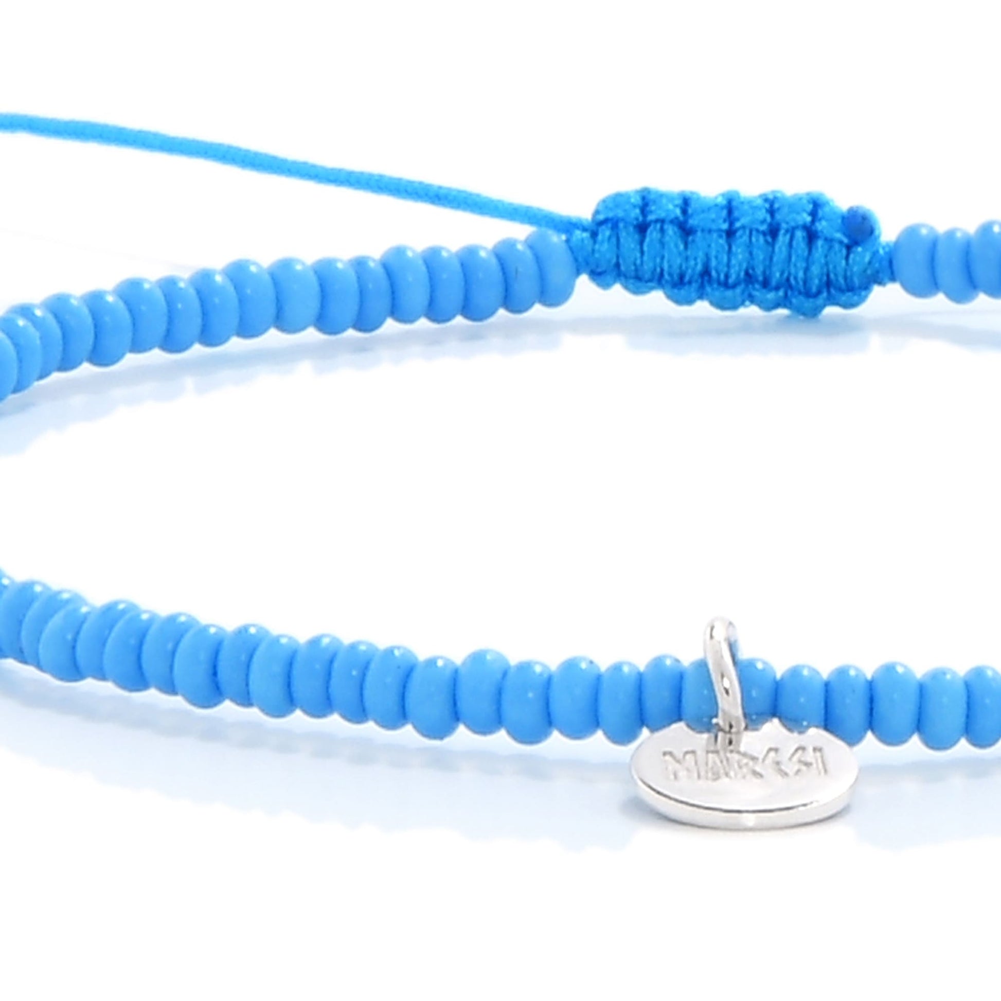 Close-up of blue beaded cross bracelet with silver charm