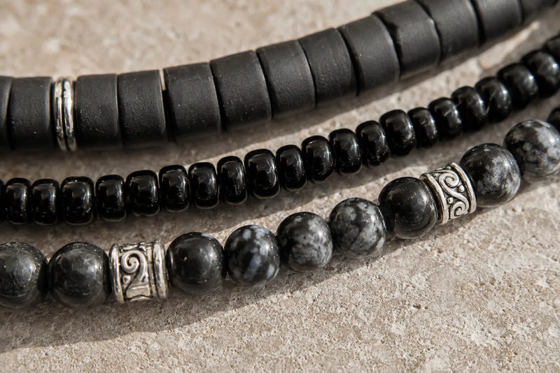 Close up of matte clay, glossy black and patterned stone beads showing how material can affect black bracelet meaning