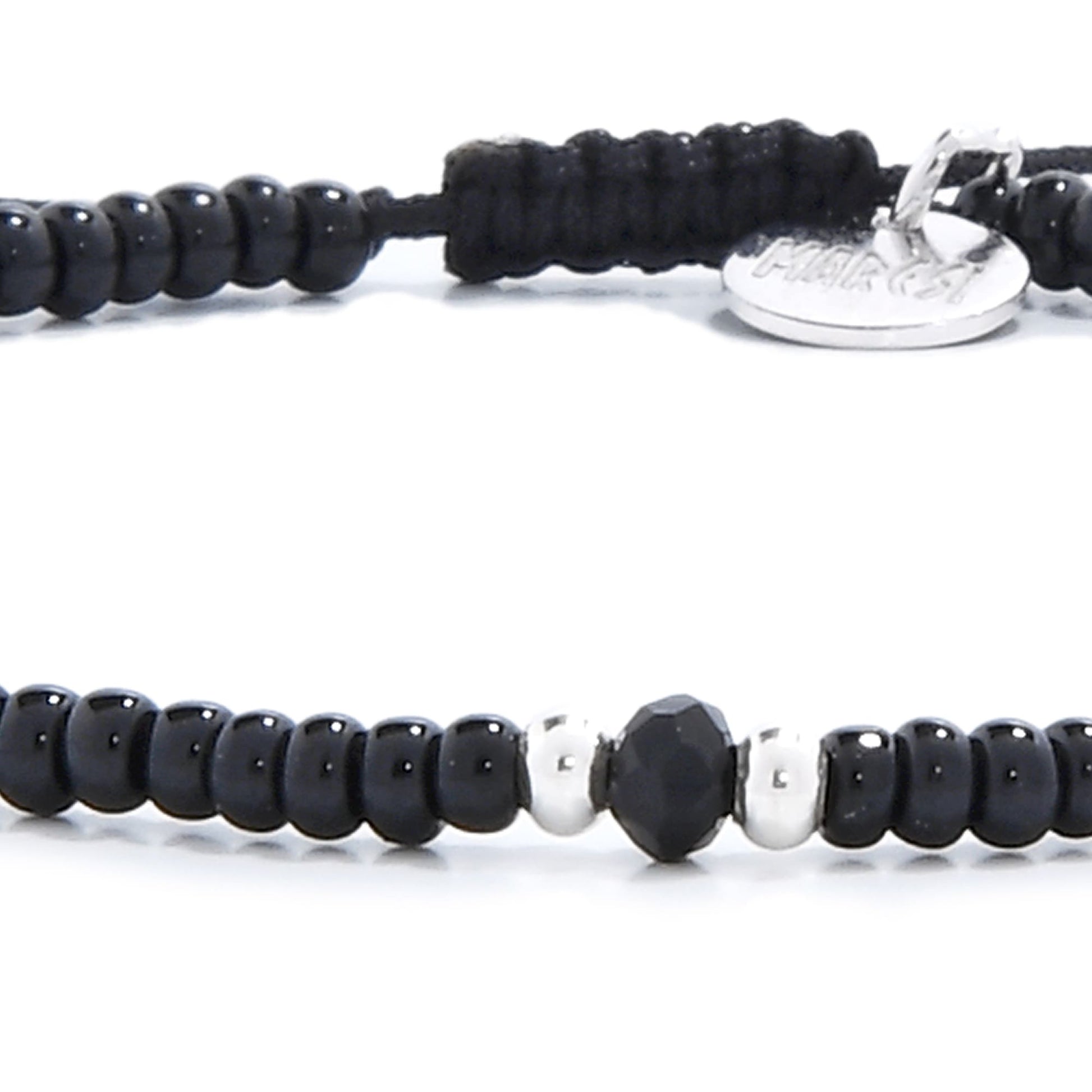 A detailed shot of the center of a mens beaded bracelet, highlighting a faceted black onyx and two silver beads.
