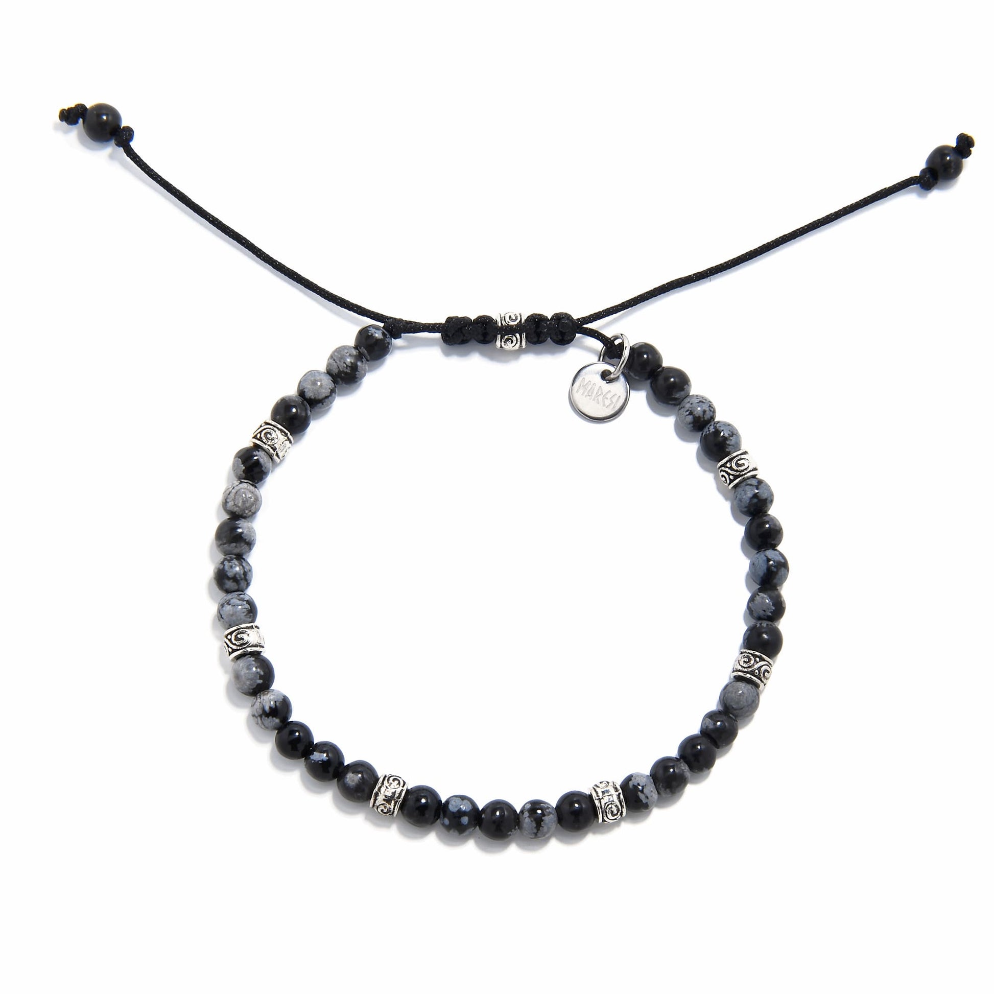 Adjustable black stone bracelet with polished jasper beads and silver detailing, laid flat.
