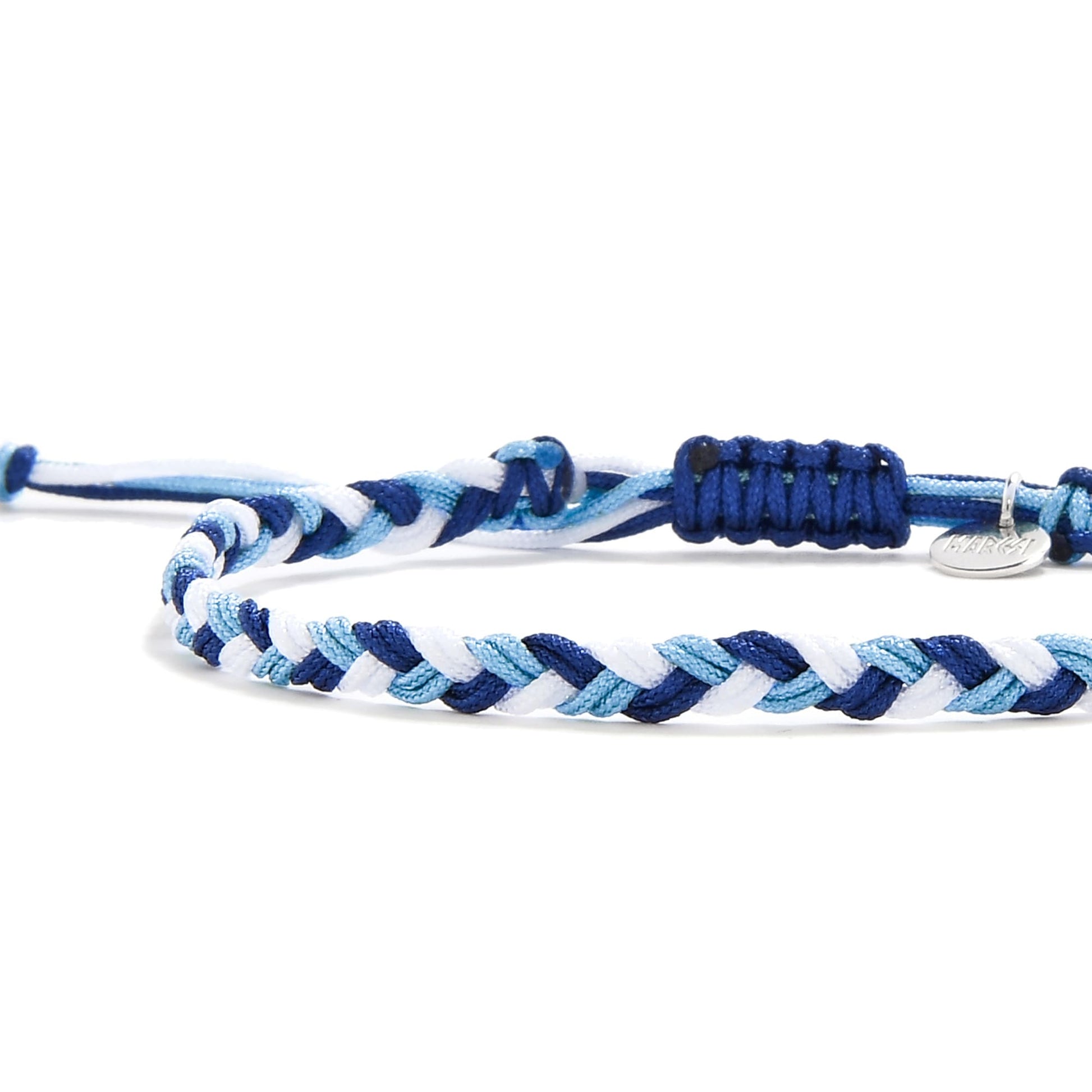 Detailed view of braided matching friendship bracelets in layered blue tones with sliding knot