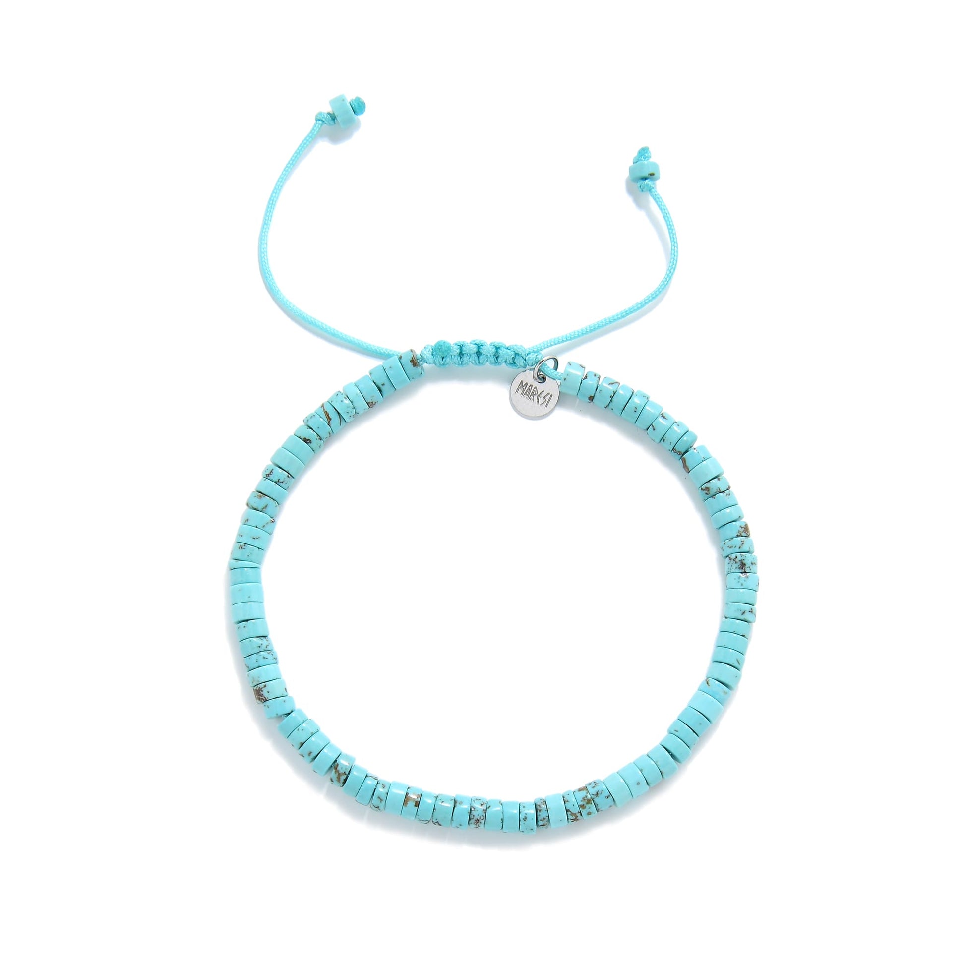 Flatlay of turquoise beads bracelet with Maresi Jewelry charm