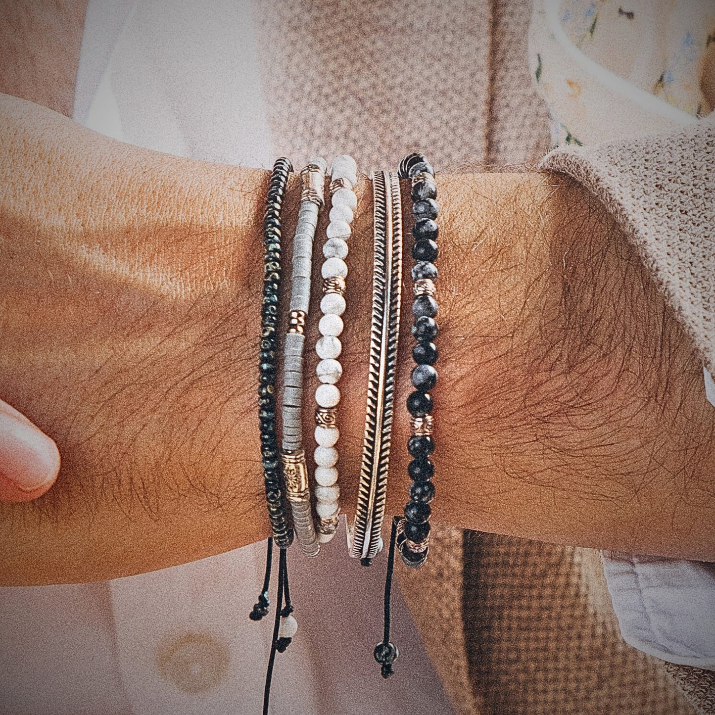 Close-up of men's wrist wearing Cannes bracelet set with black, white, and silver beads stacked for a bold look
