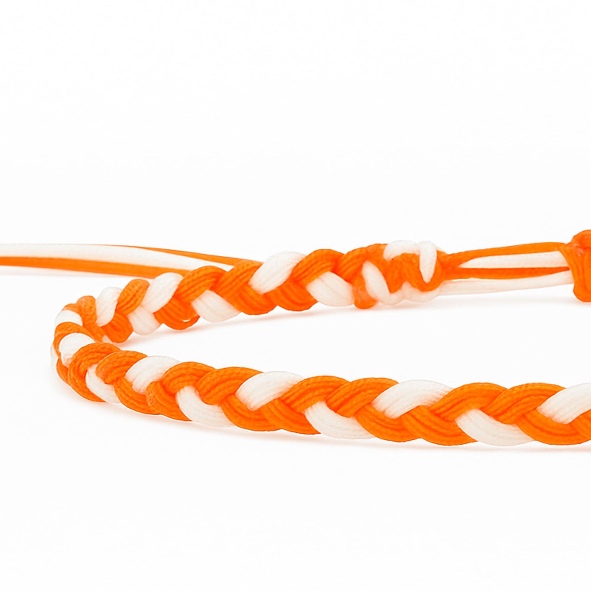 Close-up of orange and white friendship bracelet made with thread in braided design