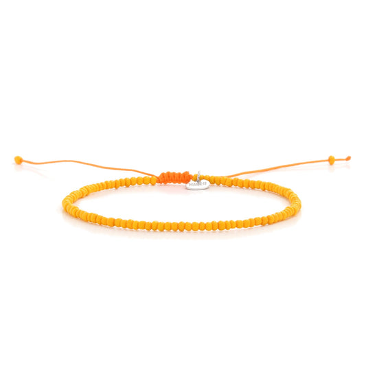 Horizontal display of orange men bead bracelet with charm