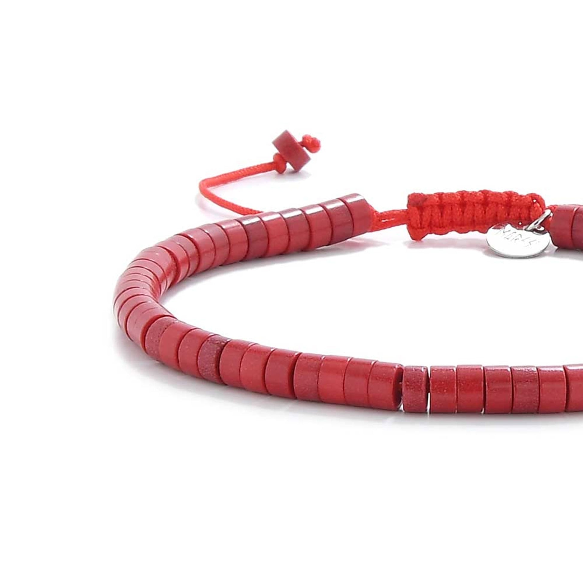 Side view of mens red string bracelet showing round clay discs on red thread
