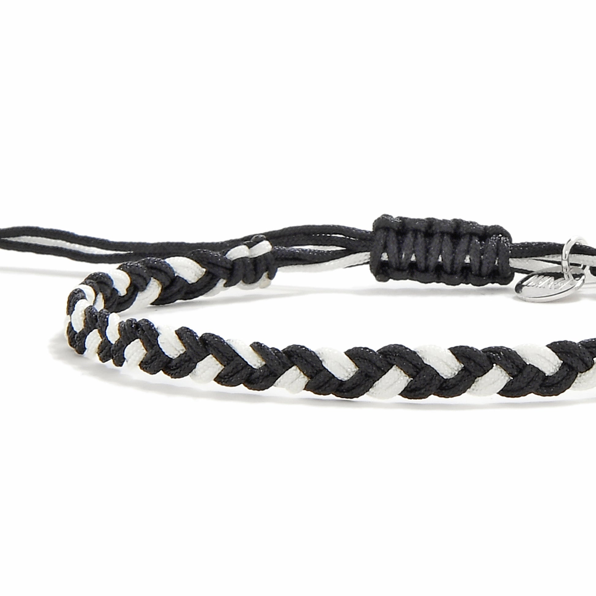 Close-up of handmade black and white friendship woven bracelet with macrame sliding knot