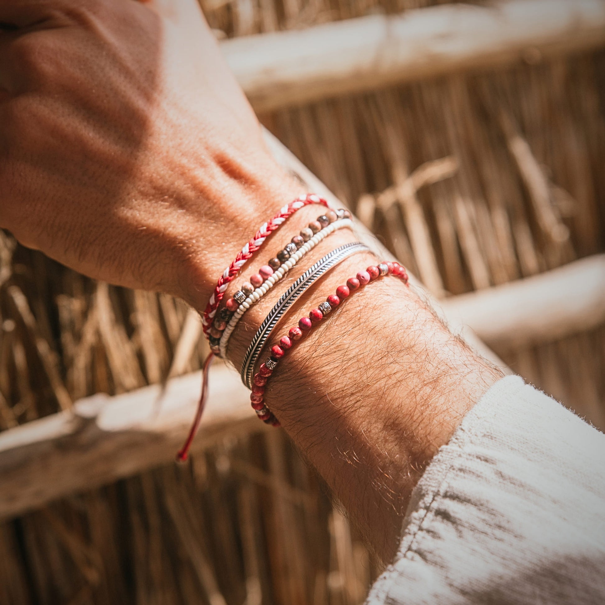 Close-up of Marseille bracelet set silver, stack bracelet with red, cream, and silver tones on wrist"