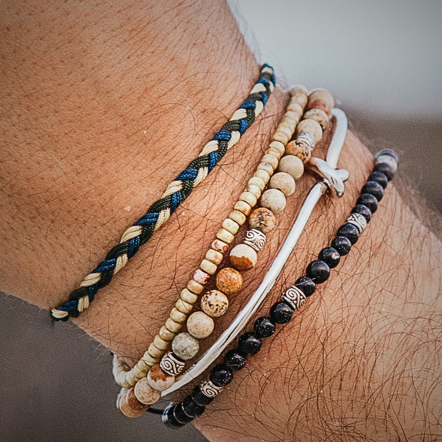 Handmade matching friendship bracelets with blue, beige, and green braided cord.