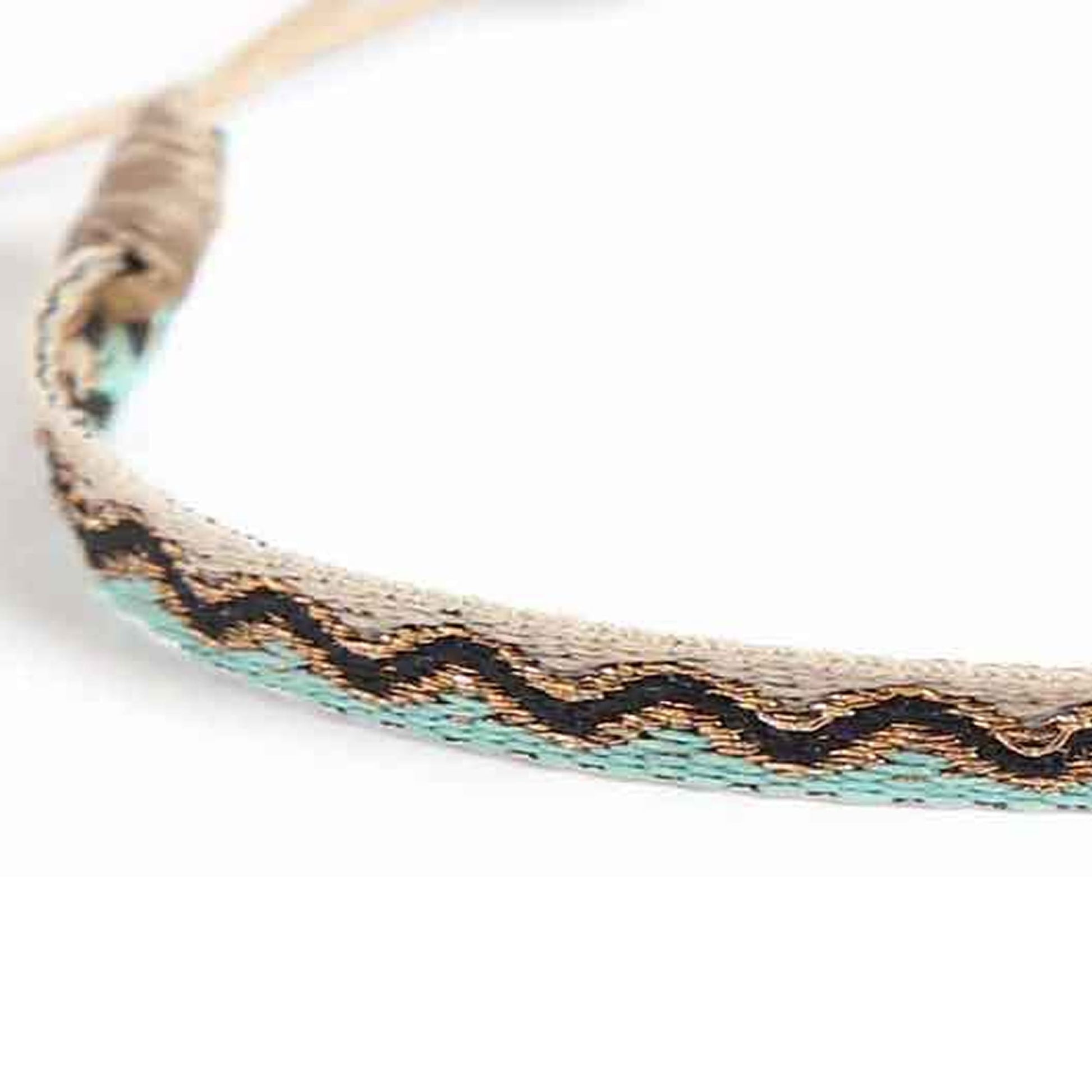Close up view of men's rope bracelets with woven beige and turquoise thread pattern.