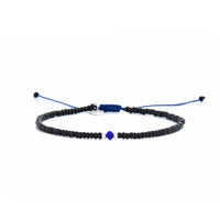 Minimalist bead bracelet with black beads, white spacers, and blue center on navy cord