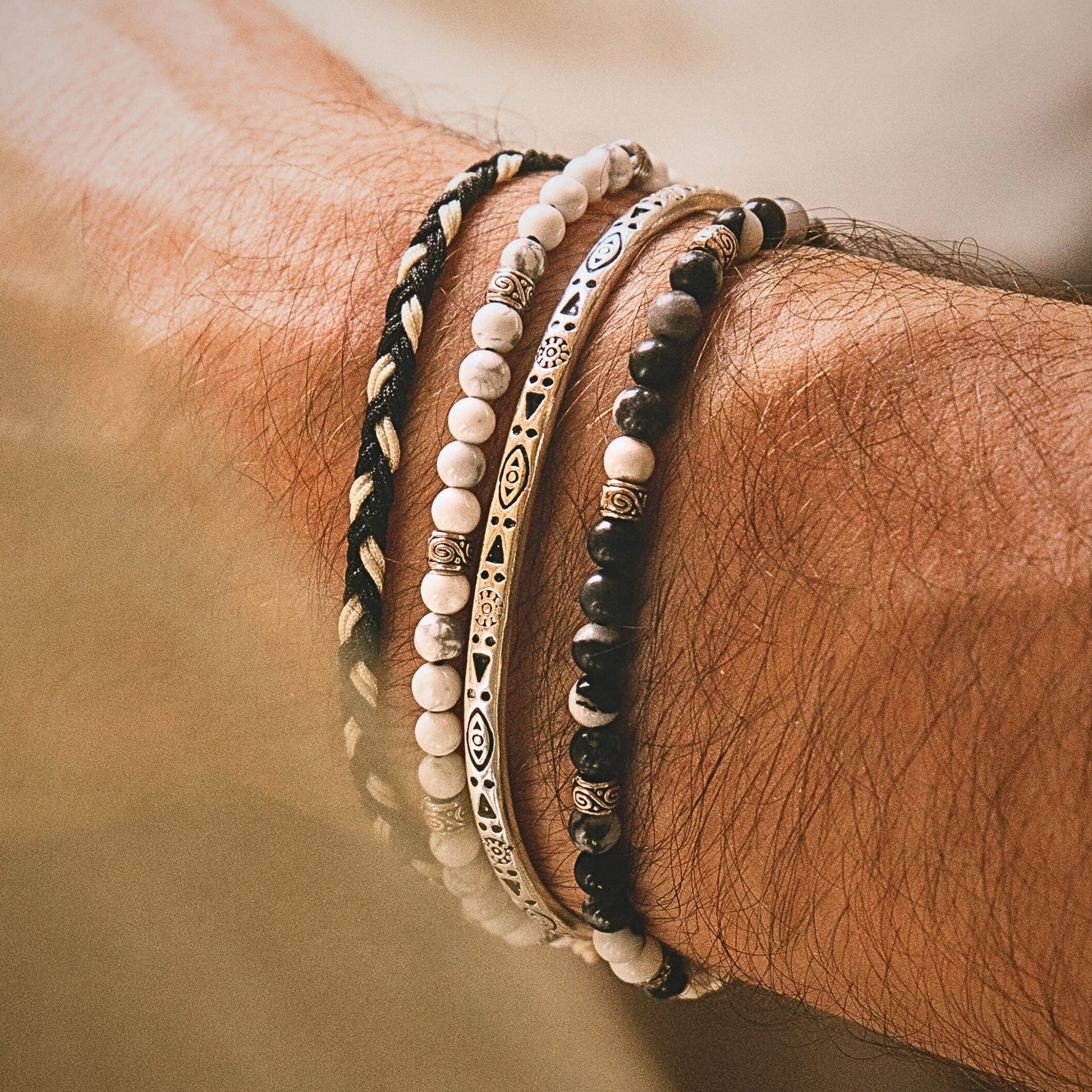 Detail shot of male silver bracelet stack from Palma set with etched silver bars and natural stone beads