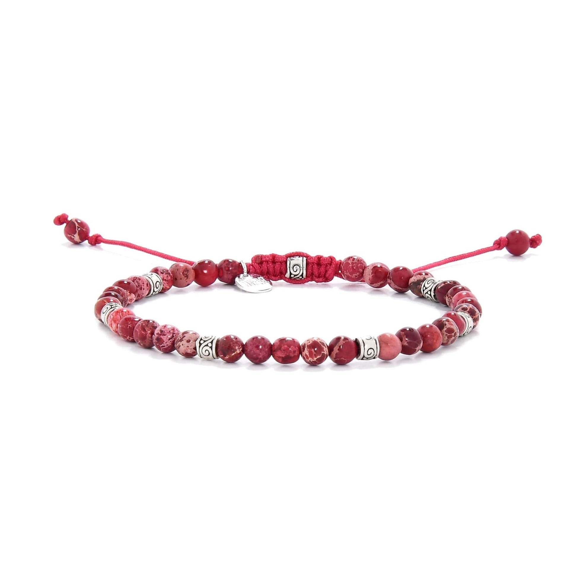 Handmade red jasper bracelet featuring round beads and silver spacers on red cord.