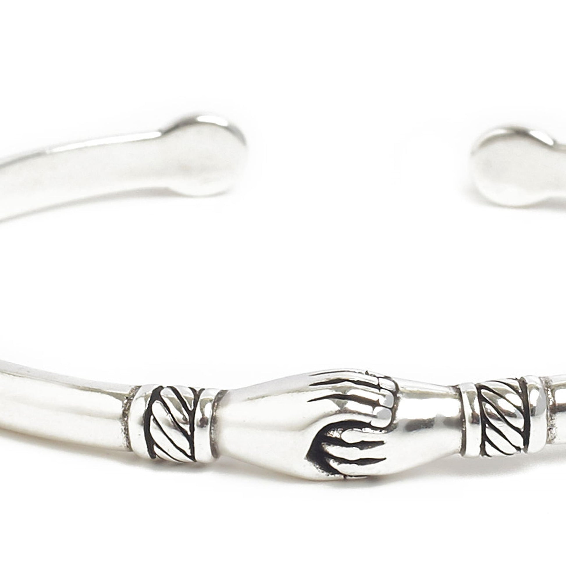 Close-up of stainless steel bracelets featuring handshake detail.