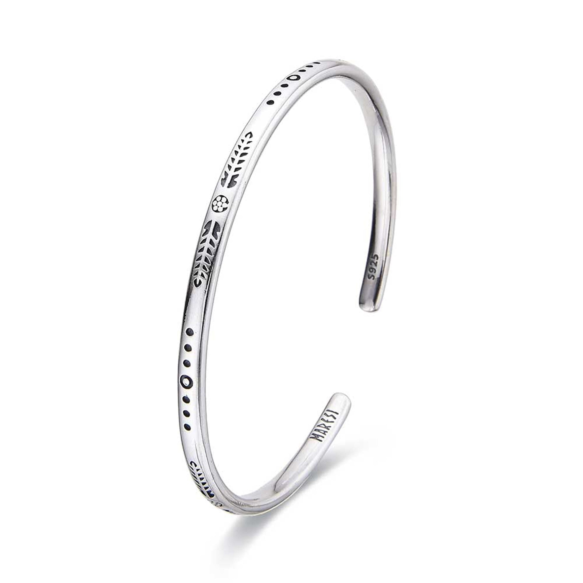 Sterling silver cuff bracelet with minimal engraved details displayed in studio.