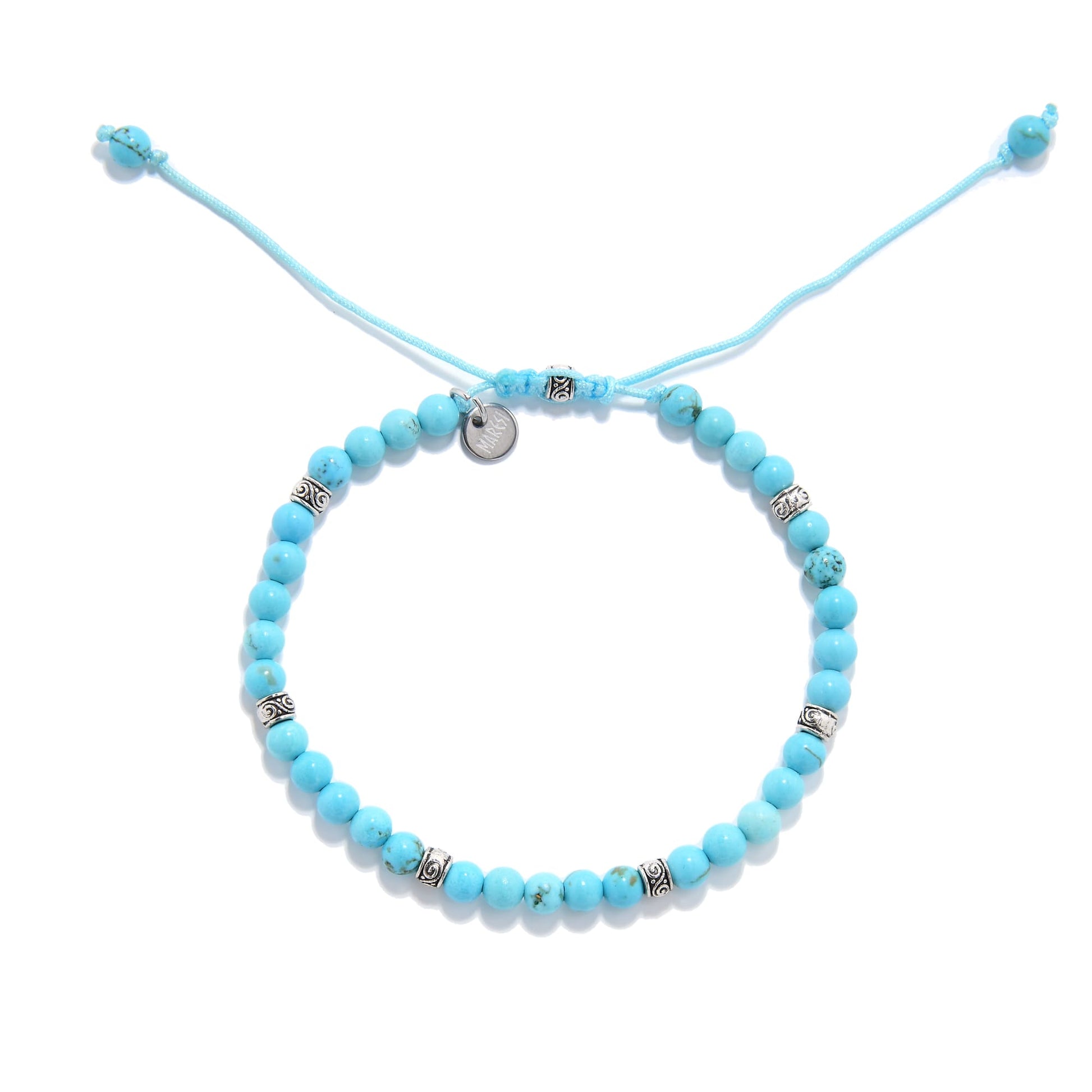 Flat lay of turquoise beaded bracelet with metal accents and blue cord