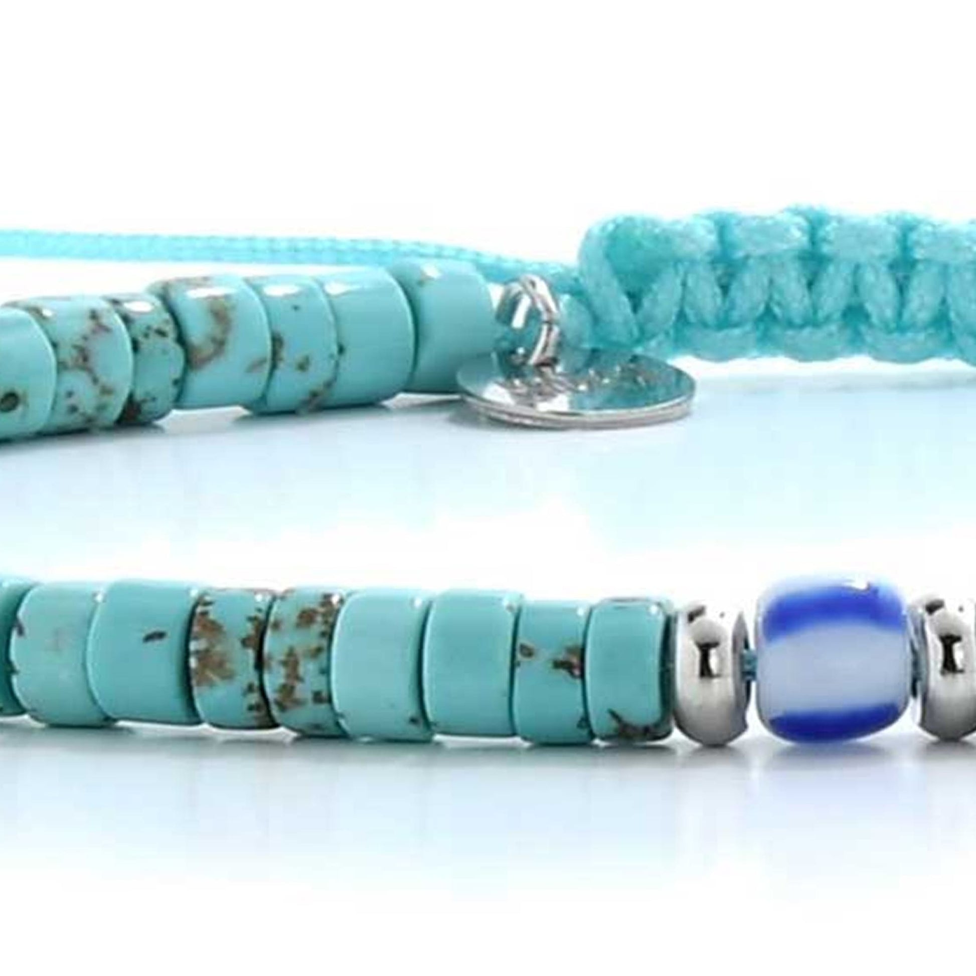 Close-up of turquoise men’s bracelets with round beads and a blue accent bead on a braided cord.