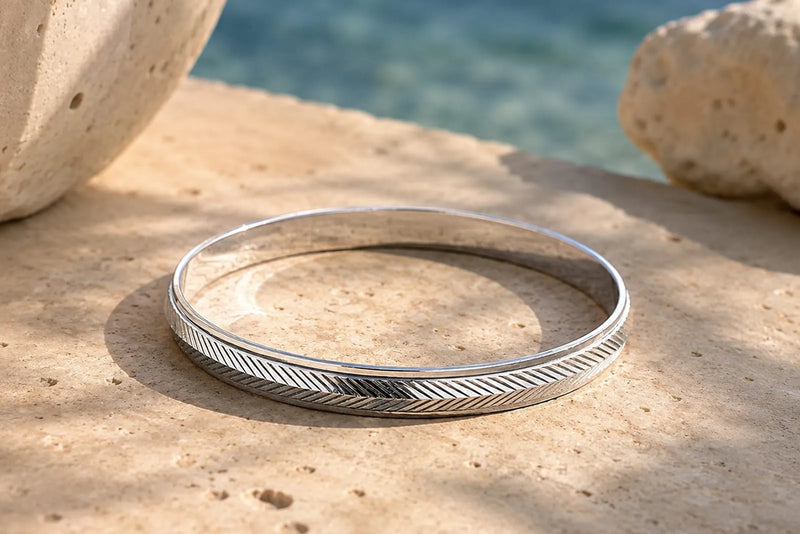 What Is a Bangle Bracelet? Silver bangle on stone
