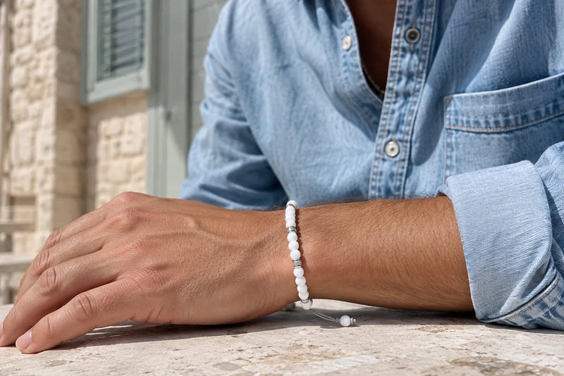 Man wearing a white jade bracelet with silver accents styled with a light blue denim shirt
