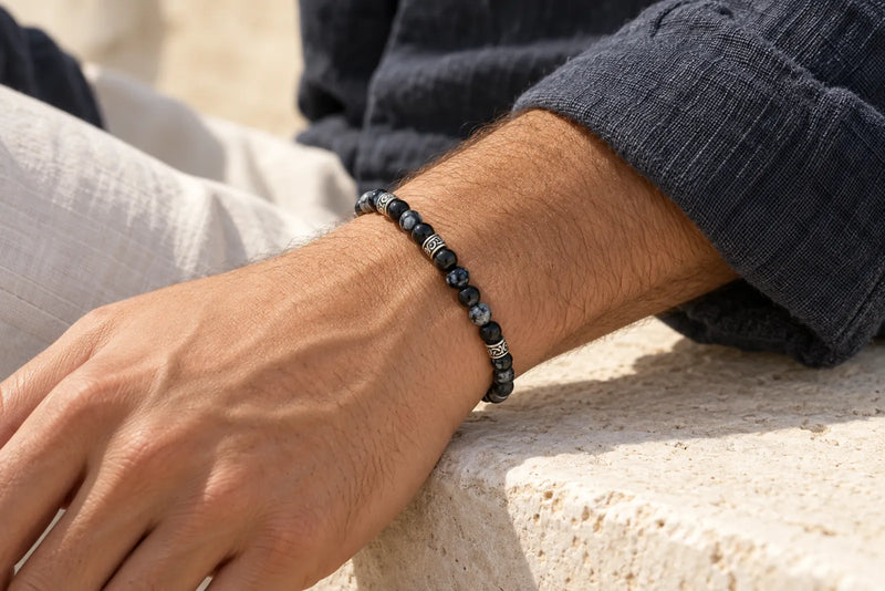 Black Jasper Bracelet with Silver-Tone Accents Black jasper bracelet illustration worn on a man's wrist beside a charcoal knit sleeve.