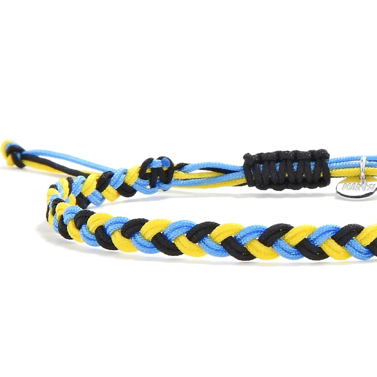 Close-up of the Carbini braided bracelet showing blue, yellow, and black cords beside the silver Maresi tag