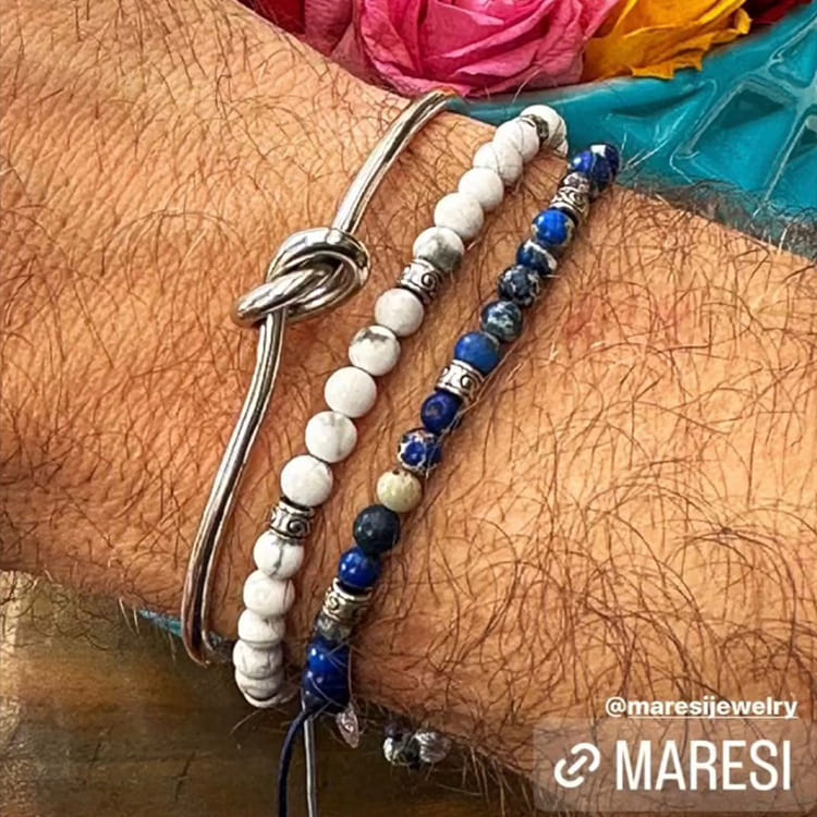 Two bracelets on a wrist with a colorful background, featuring the brand 'MARESI'.