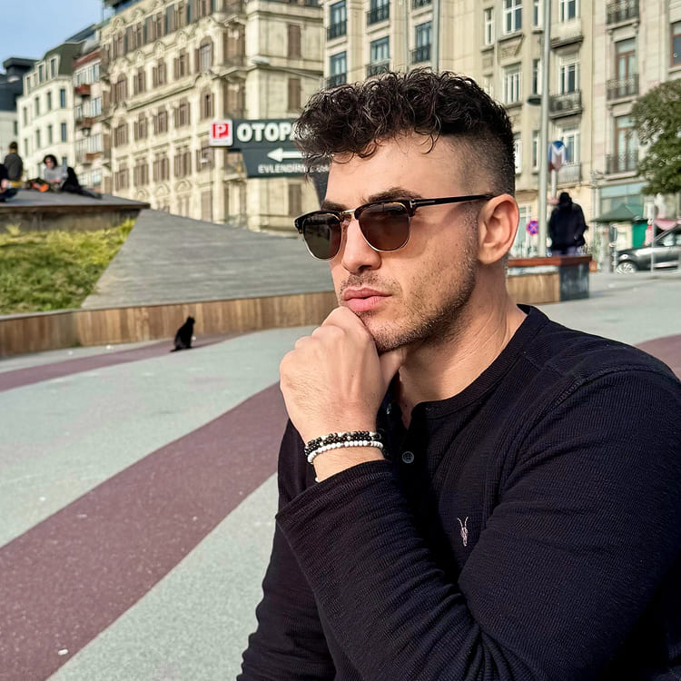 Man wearing sunglasses and a black shirt in an urban setting