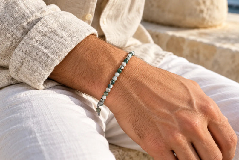 Moss Agate Bracelet with a Linen Shirt Green-and-white moss agate bead bracelet worn on a man's wrist beside a beige linen shirt cuff.