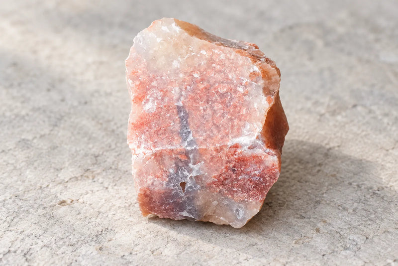 Pink chalcedony: rough pink specimen Rough pink chalcedony with pale areas and darker markings along one edge.