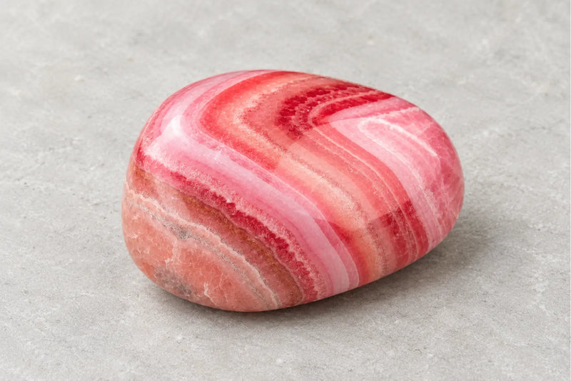 Rhodochrosite: pink and white banded stone Polished rhodochrosite with curved pink and pale bands.