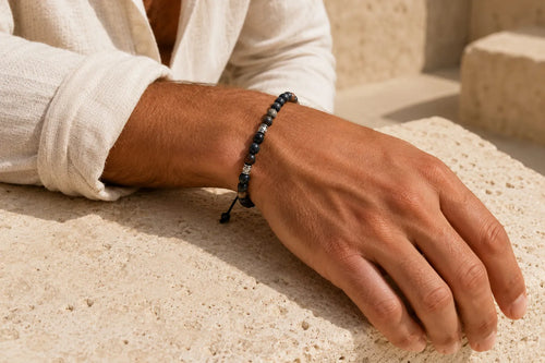 Black bracelet meaning shown through a men’s dark beaded bracelet worn with a white linen shirt