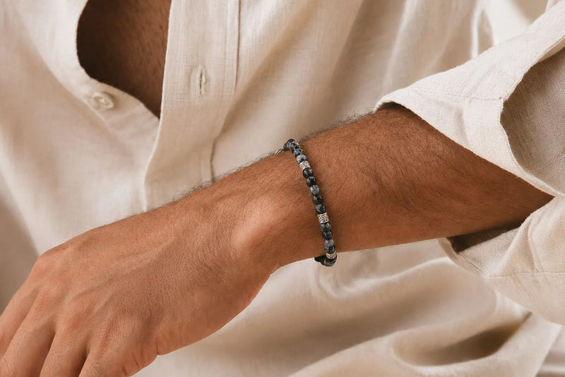 Black jade bracelet for men with polished dark beads and silver details, styled with a white linen shirt.