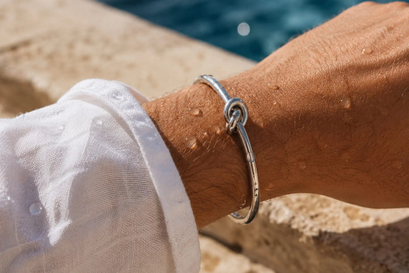 Does stainless steel tarnish? Men’s stainless steel bracelet worn by the water with visible droplets.
