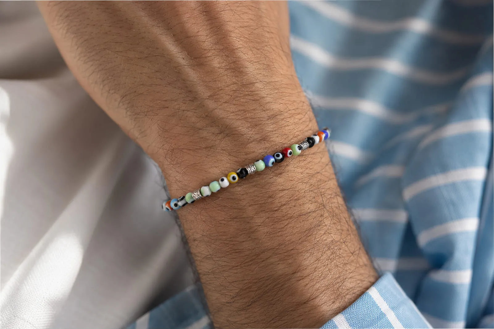 Evil Eye Bracelet Colors, featuring multicolored evil eye beads and silver details on a men’s seed bead bracelet.