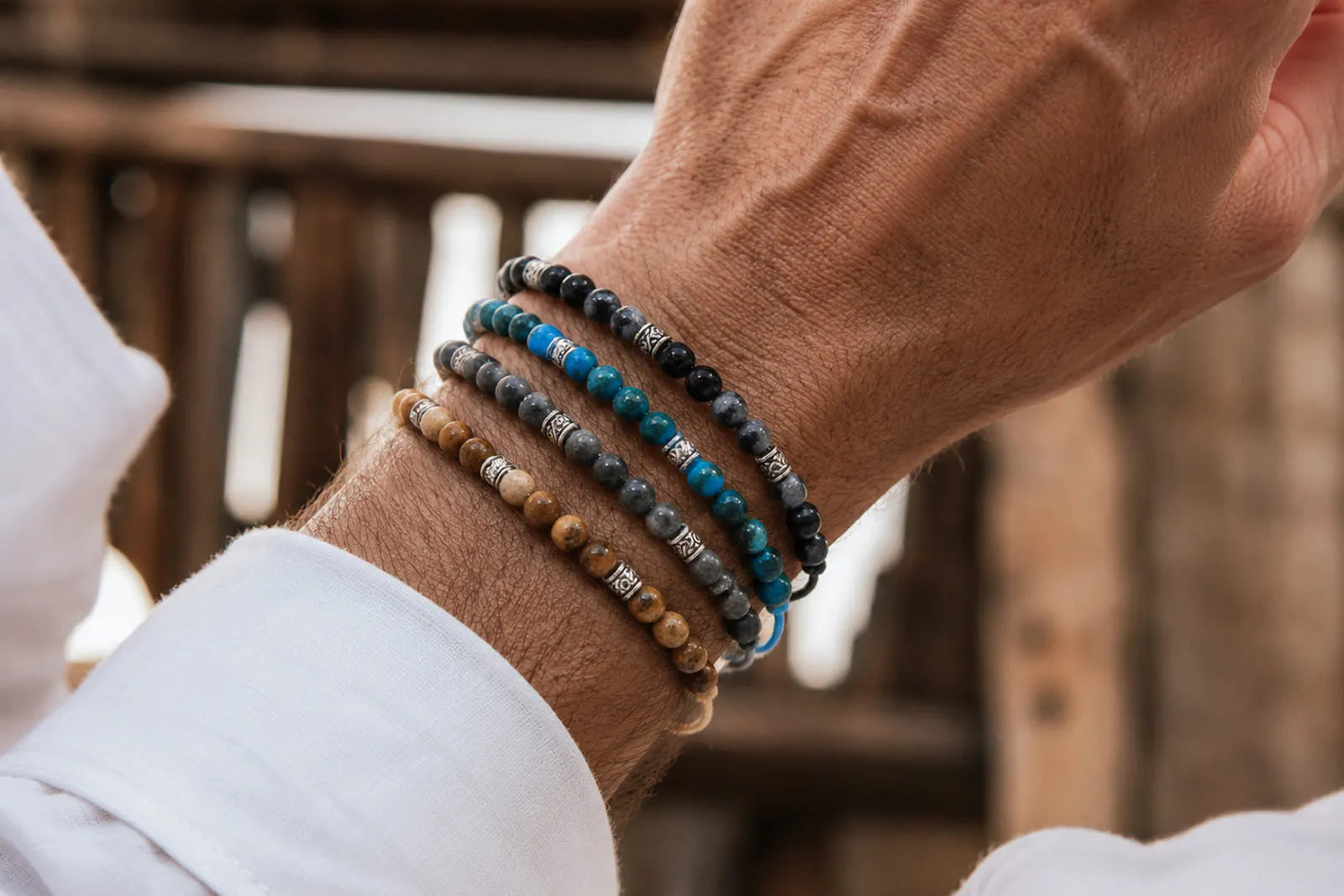 Gemstone bracelet for men featuring stacked blue, gray, black and brown stone beads with silver-tone details.