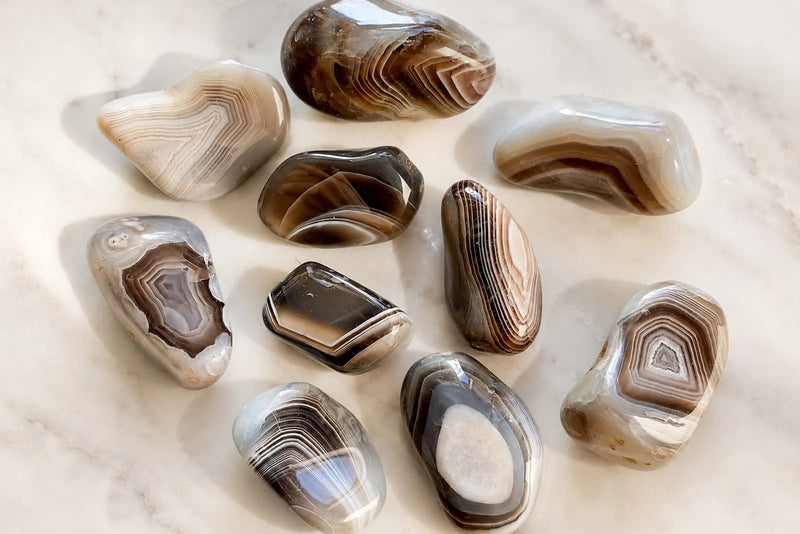 Gray stones names and types shown through polished banded agate stones in soft gray, brown, cream, and white tones.