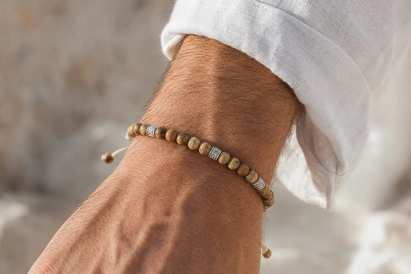 Picture Jasper bracelet for men featuring natural brown stone beads and silver details on a wrist with a white linen shirt.