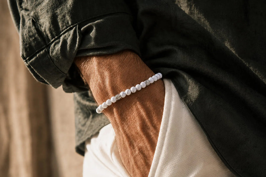 Real white howlite or fake bracelet comparison featuring white stone beads with subtle gray veining on a man’s wrist.