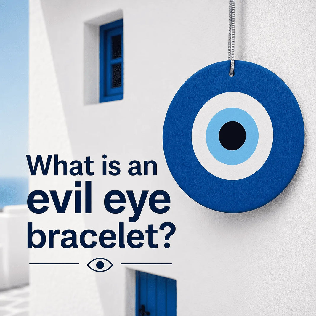 What is an evil eye bracelet? Blue evil eye symbol on a white Mediterranean wall with blog title text