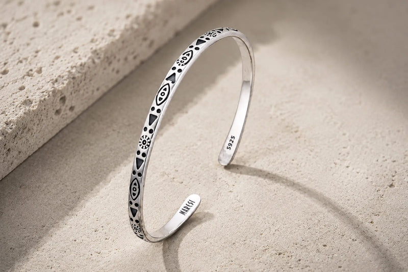 925 sterling silver cuff bracelet with visible S925 hallmark on a warm stone background