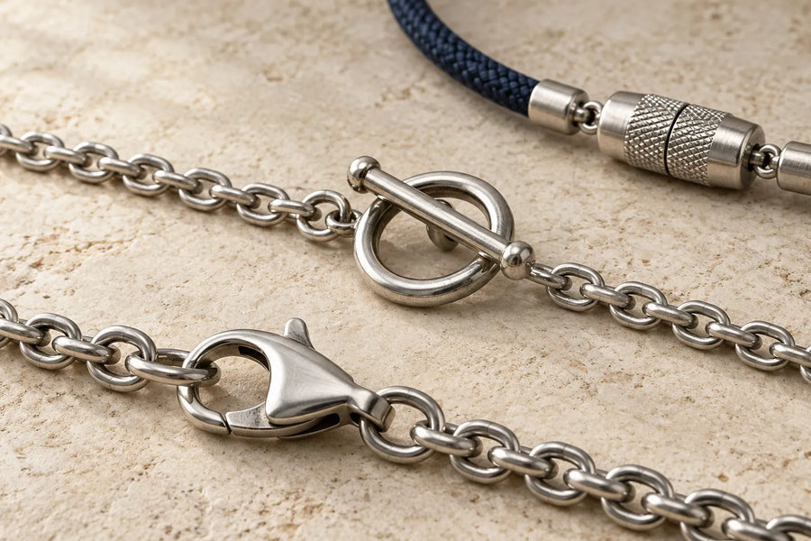 Types of bracelet clasps shown close up: lobster and toggle clasps on chains, plus a barrel clasp on navy cord.