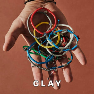 Clay brads bracelets on open hand with neutral background.