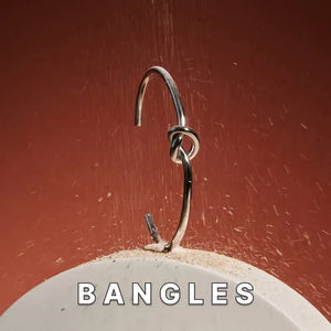 Close-up of Maresi metal bracelet bangle with knot detail