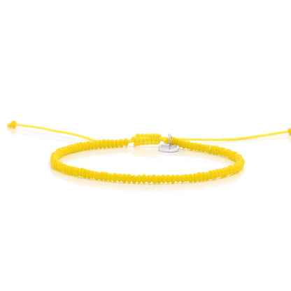 Handmade yellow bead bracelet with adjustable cord and silver charm